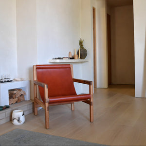 Modern interior with a red leather chair, fireplace, and decorations