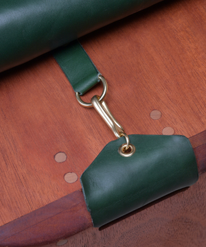Close-up shot of custom wooden bench with gold hardware and leather details 
